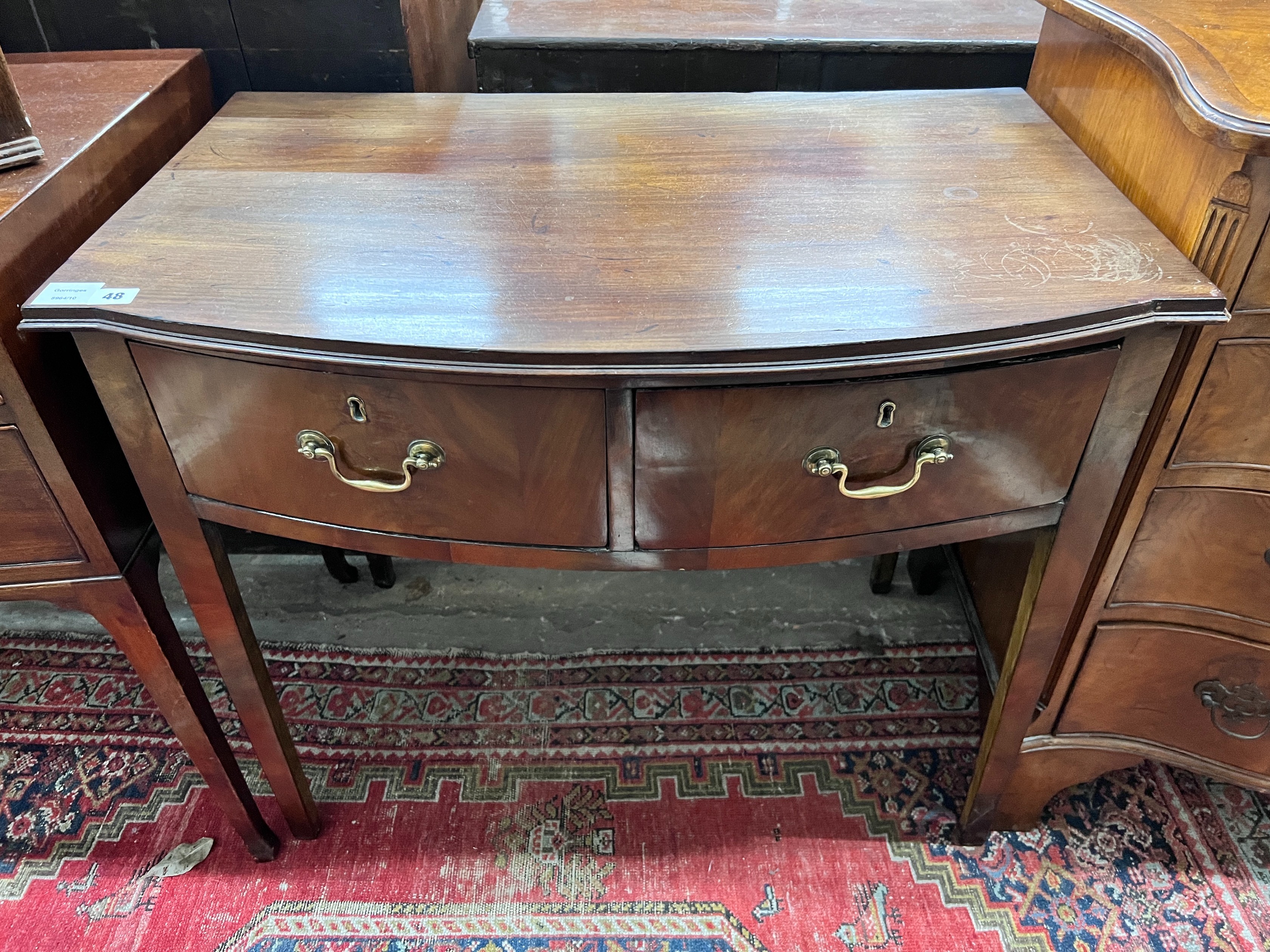 A George III mahogany bowfront two drawer side table, width 86cm, depth 54cm, height 74cm *Please note the sale commences at 9am.